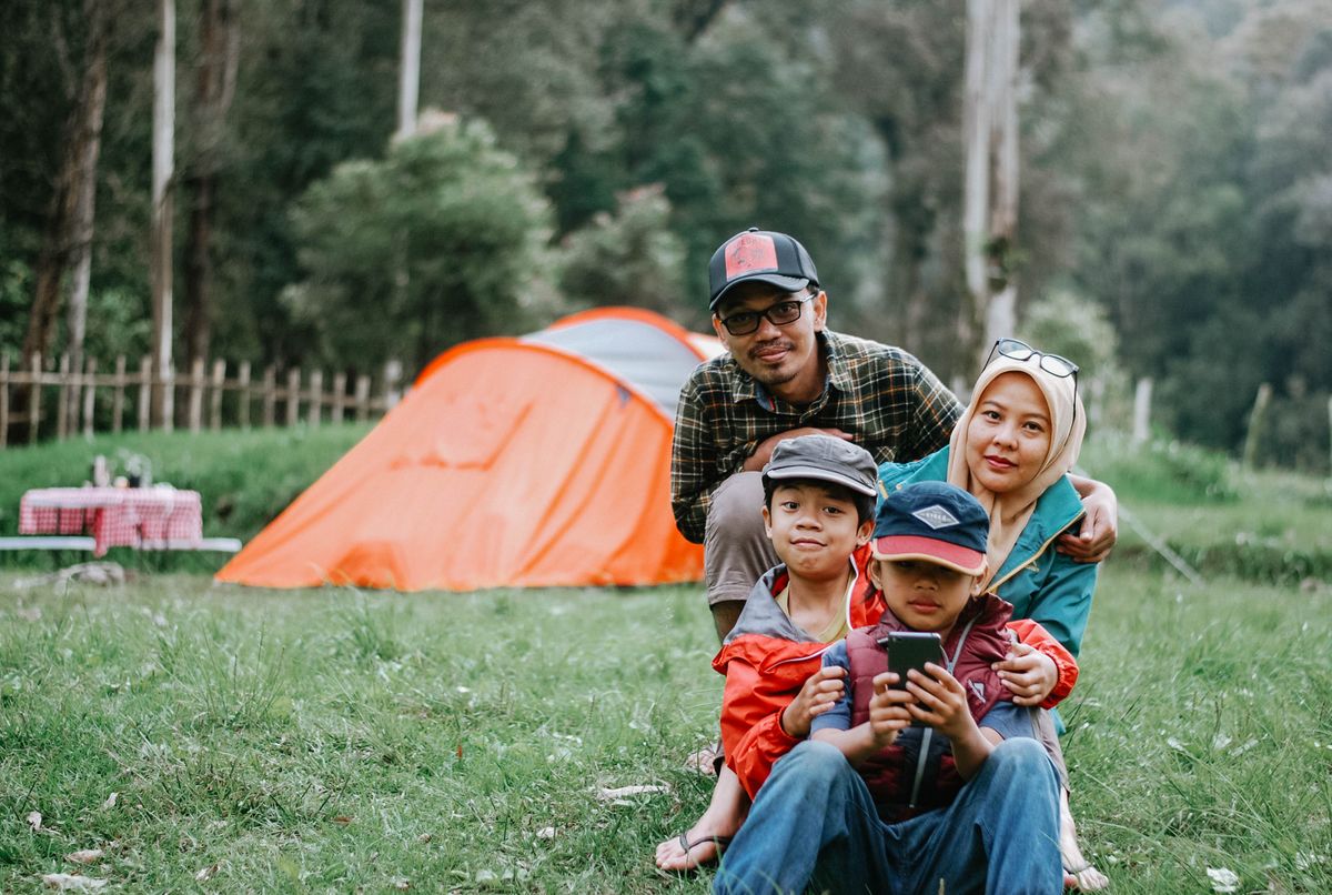 Family camping tent setup in a forest clearing
